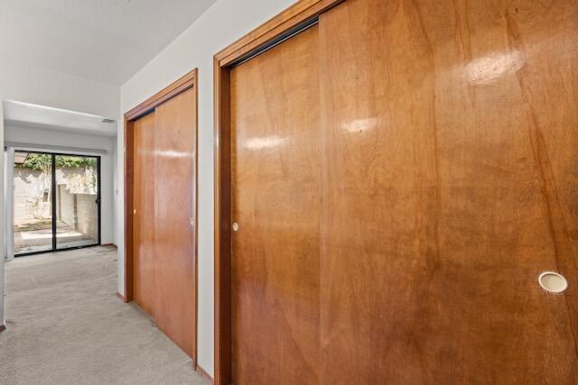 hallway featuring light carpet