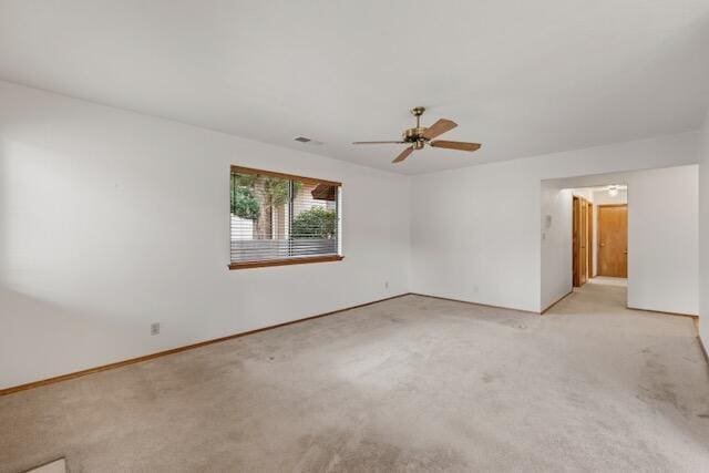 unfurnished room featuring visible vents, light colored carpet, baseboards, and a ceiling fan