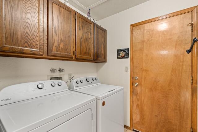 clothes washing area featuring washing machine and clothes dryer and cabinet space