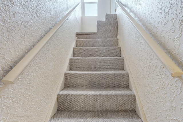 stairs featuring a textured wall