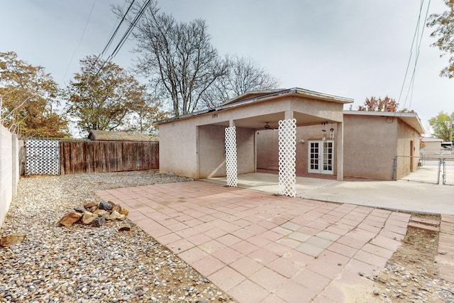 rear view of house featuring ceiling fan, a fenced backyard, a patio, and stucco siding