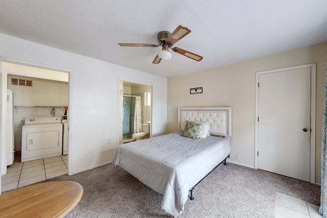 carpeted bedroom with visible vents, ensuite bathroom, freestanding refrigerator, separate washer and dryer, and tile patterned floors