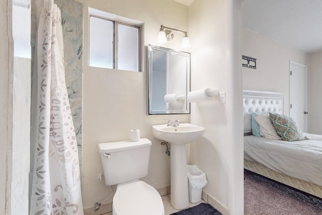 ensuite bathroom featuring a shower with shower curtain, ensuite bath, and toilet