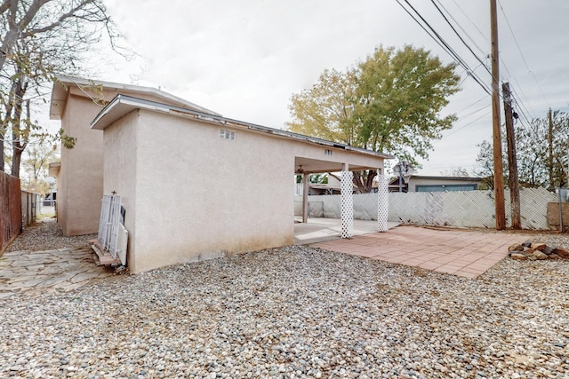 back of property with stucco siding, fence, and a patio