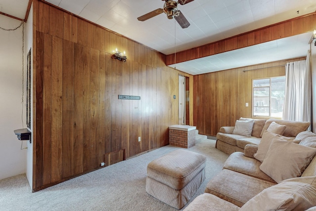 carpeted living room with ceiling fan and wooden walls