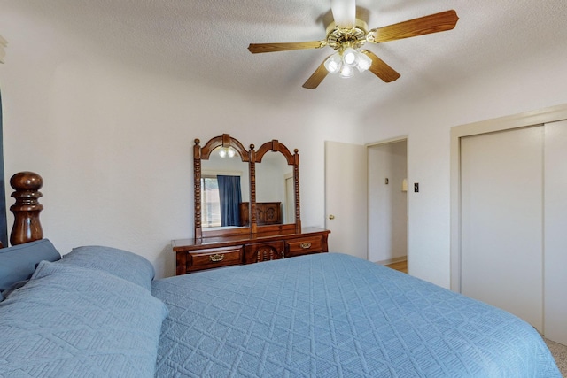 bedroom with a textured ceiling, ceiling fan, and a closet