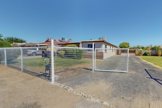 ranch-style home with a gate and fence