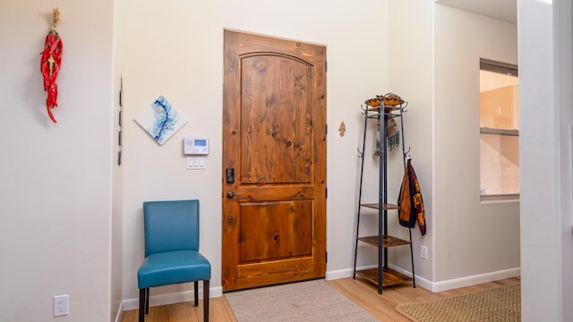 foyer entrance featuring baseboards and wood finished floors