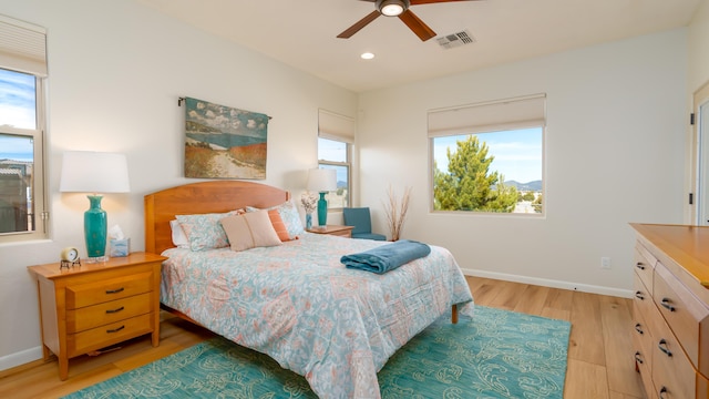 bedroom with light wood finished floors, multiple windows, and visible vents