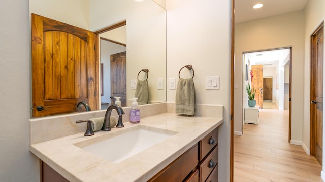 bathroom featuring recessed lighting, wood finished floors, and vanity