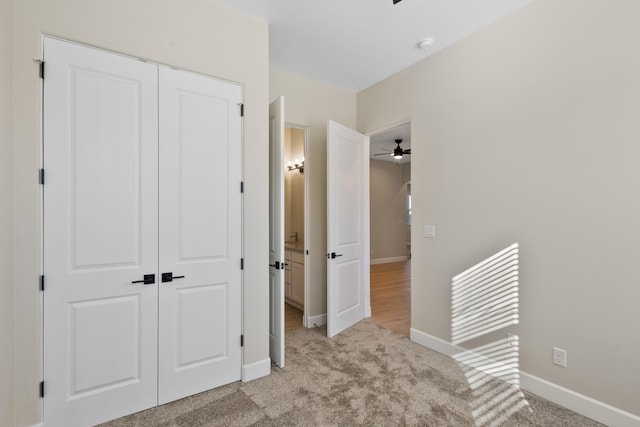 interior space with light carpet, baseboards, and a closet