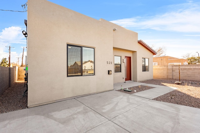 rear view of property with a patio, a fenced backyard, and stucco siding