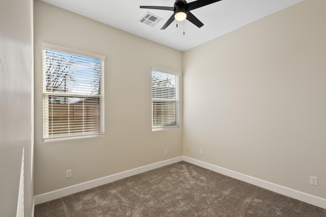 carpeted spare room featuring visible vents, ceiling fan, and baseboards