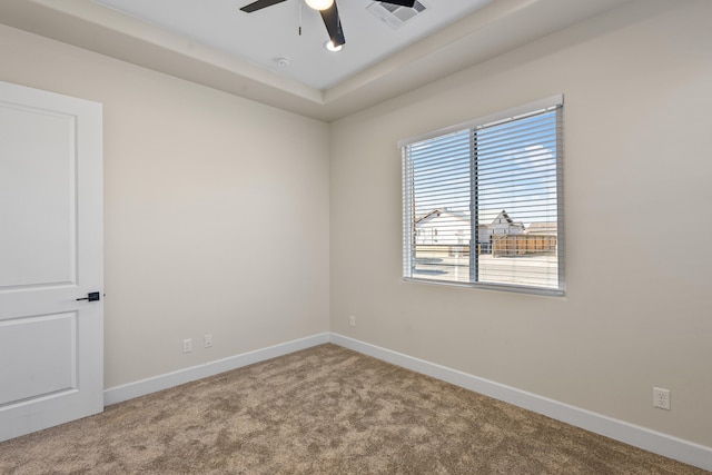 unfurnished room with carpet floors, a ceiling fan, visible vents, and baseboards