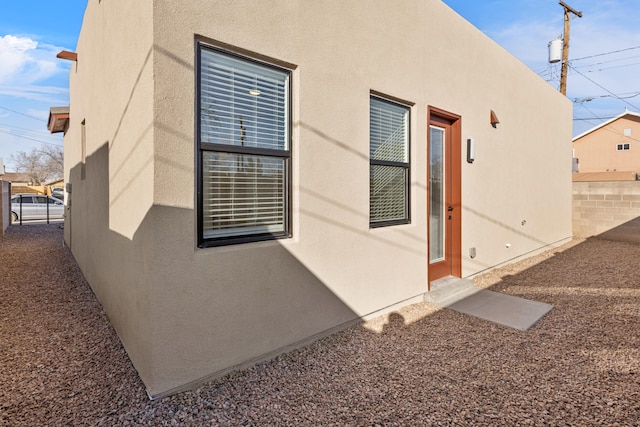 view of property exterior with fence and stucco siding