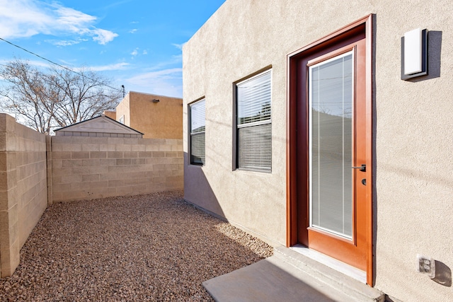 exterior space featuring fence and stucco siding