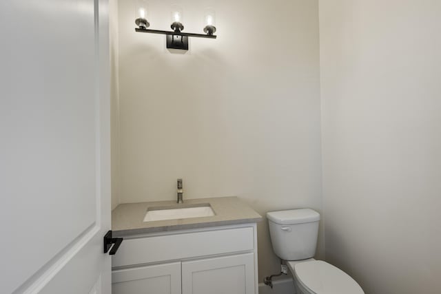 half bathroom with vanity and toilet