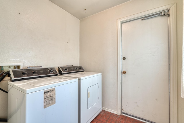 washroom with laundry area, baseboards, brick floor, and washer and dryer