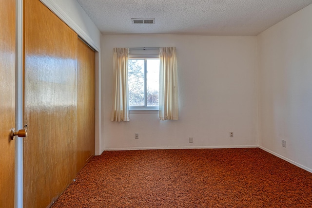 interior space featuring baseboards, visible vents, and a textured ceiling