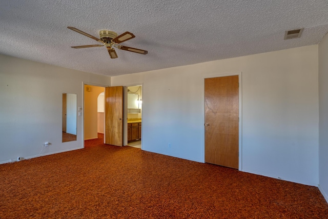 unfurnished bedroom featuring carpet, visible vents, a textured ceiling, and ensuite bathroom