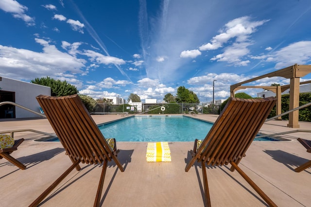 pool with a patio area and fence