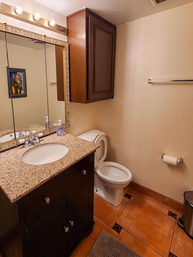 bathroom featuring toilet, visible vents, baseboards, vanity, and tile patterned floors