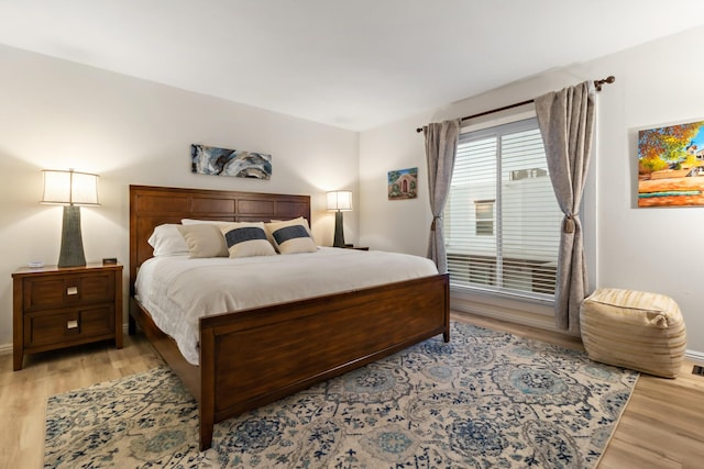 bedroom featuring light wood-style floors and baseboards