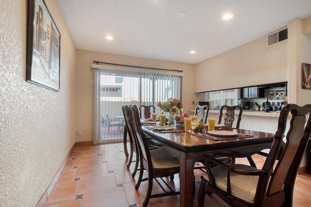 dining area with light tile patterned floors, baseboards, visible vents, a textured wall, and recessed lighting