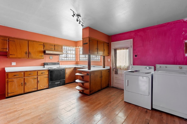 kitchen with electric range, washer and clothes dryer, and brown cabinets