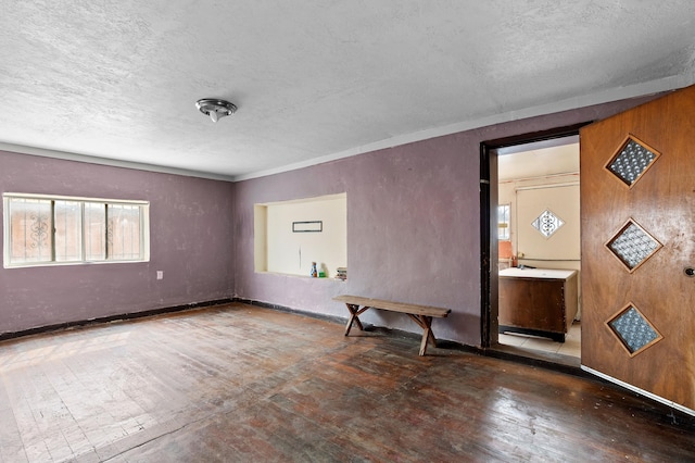 empty room featuring baseboards and a textured ceiling