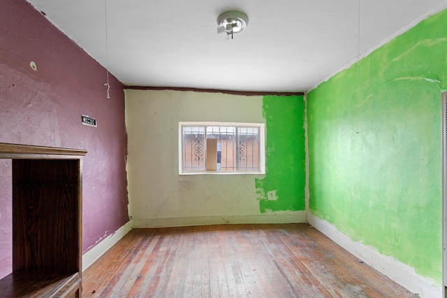 unfurnished room featuring hardwood / wood-style floors and baseboards