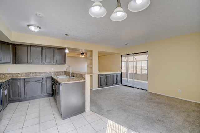 kitchen featuring light tile patterned flooring, light carpet, a peninsula, a sink, and open floor plan