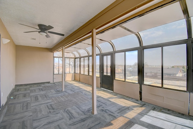 unfurnished sunroom with plenty of natural light, visible vents, and a ceiling fan