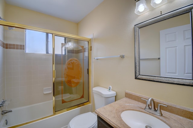 bathroom with toilet, combined bath / shower with glass door, and vanity