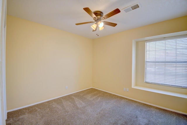 unfurnished room with a ceiling fan, baseboards, visible vents, and carpet flooring