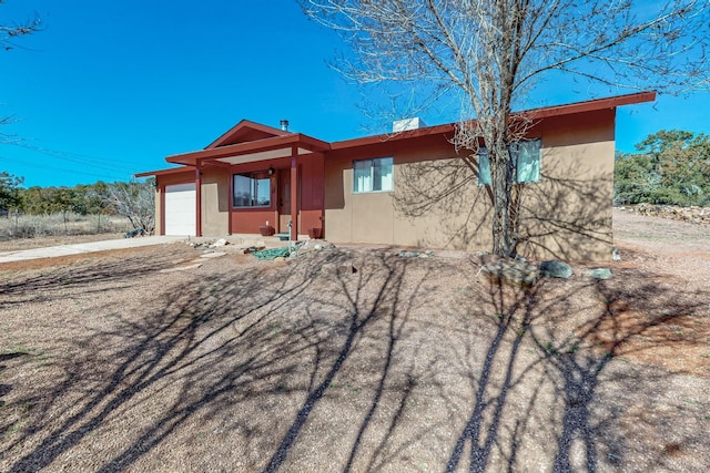 view of front of house featuring driveway, an attached garage, and stucco siding