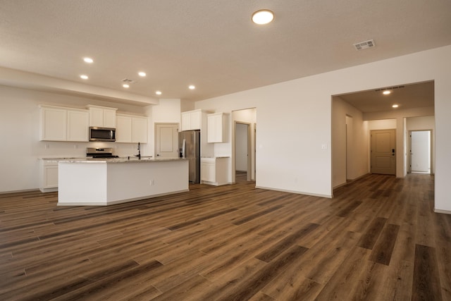 kitchen featuring appliances with stainless steel finishes, white cabinets, visible vents, and dark wood-style flooring