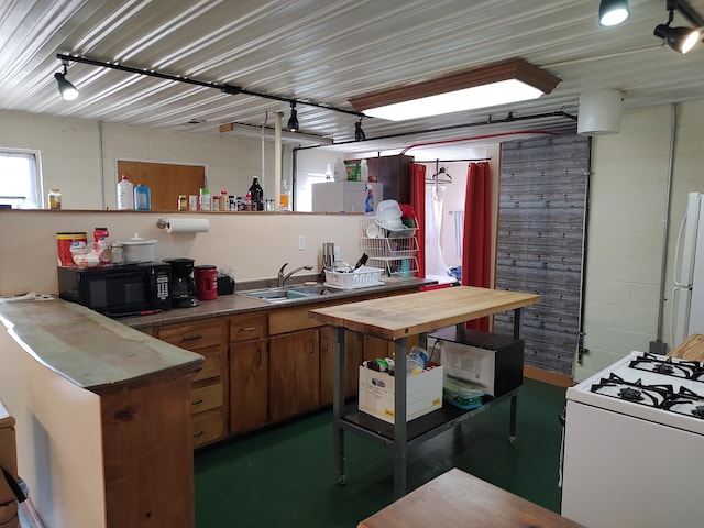 kitchen featuring open shelves, a sink, white gas range oven, black microwave, and wood counters