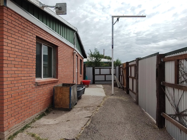 view of property exterior with fence and brick siding