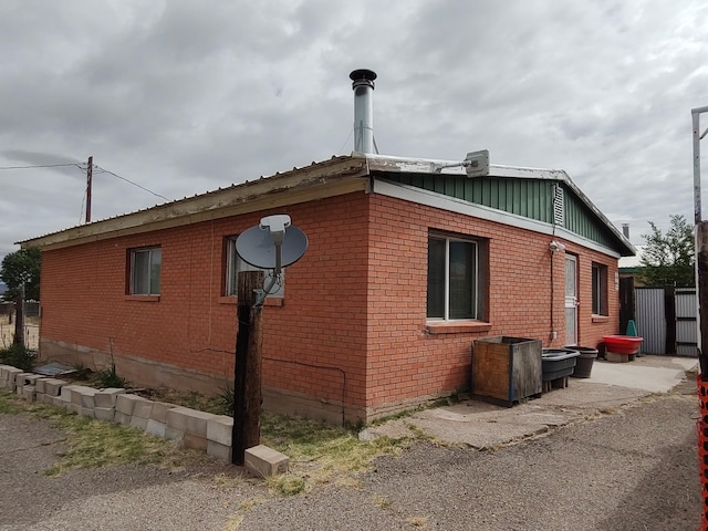 view of property exterior featuring board and batten siding and brick siding