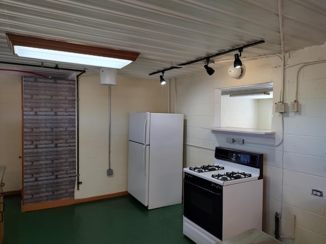 kitchen with track lighting, gas stove, freestanding refrigerator, and finished concrete floors