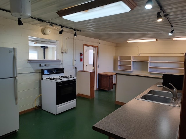 kitchen with a sink, open shelves, freestanding refrigerator, range with gas cooktop, and rail lighting