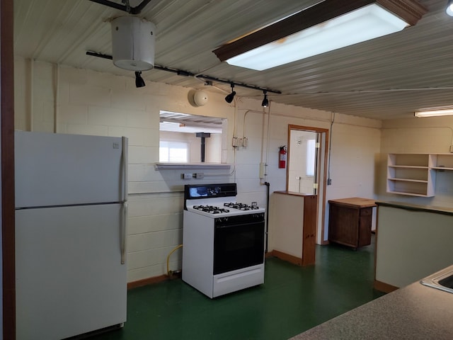 kitchen featuring white appliances, finished concrete flooring, and track lighting