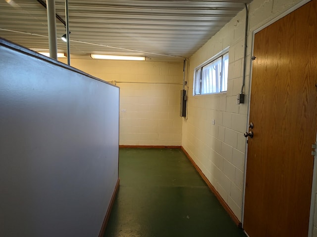 hallway featuring concrete block wall and concrete flooring