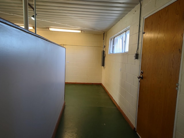 hall with concrete block wall and concrete flooring