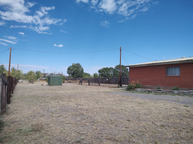 view of yard featuring an outbuilding, a fenced backyard, and a shed