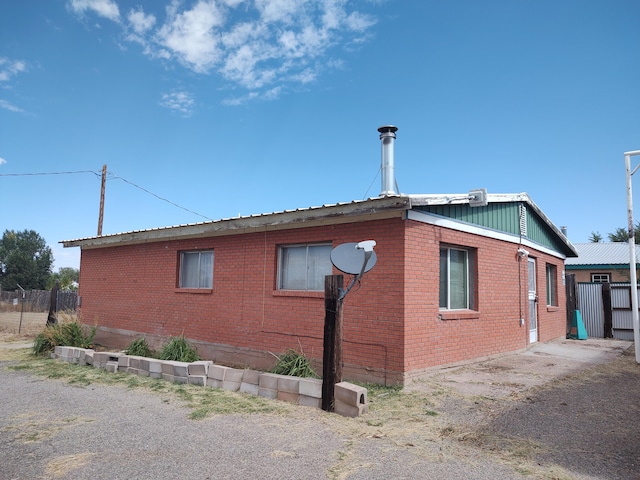 view of home's exterior with fence and brick siding