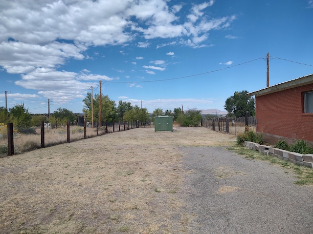 view of yard featuring an outdoor structure and fence