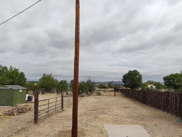 view of yard featuring a storage unit, an outbuilding, and fence