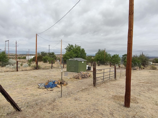 view of yard featuring a storage shed, fence, and an outdoor structure